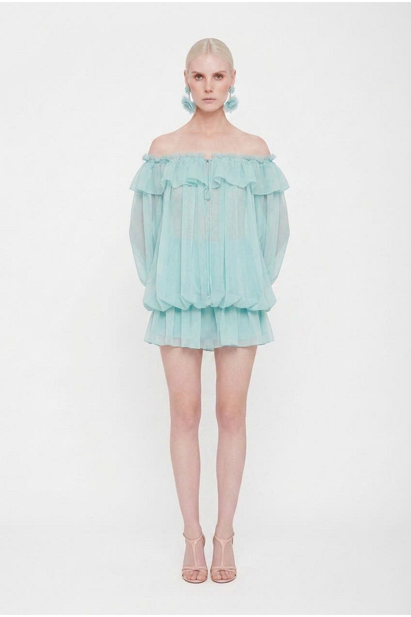 Valenciani off-shoulder mini dress styled as a scarf, featuring soft fabric and vibrant pattern, showcased on a mannequin.