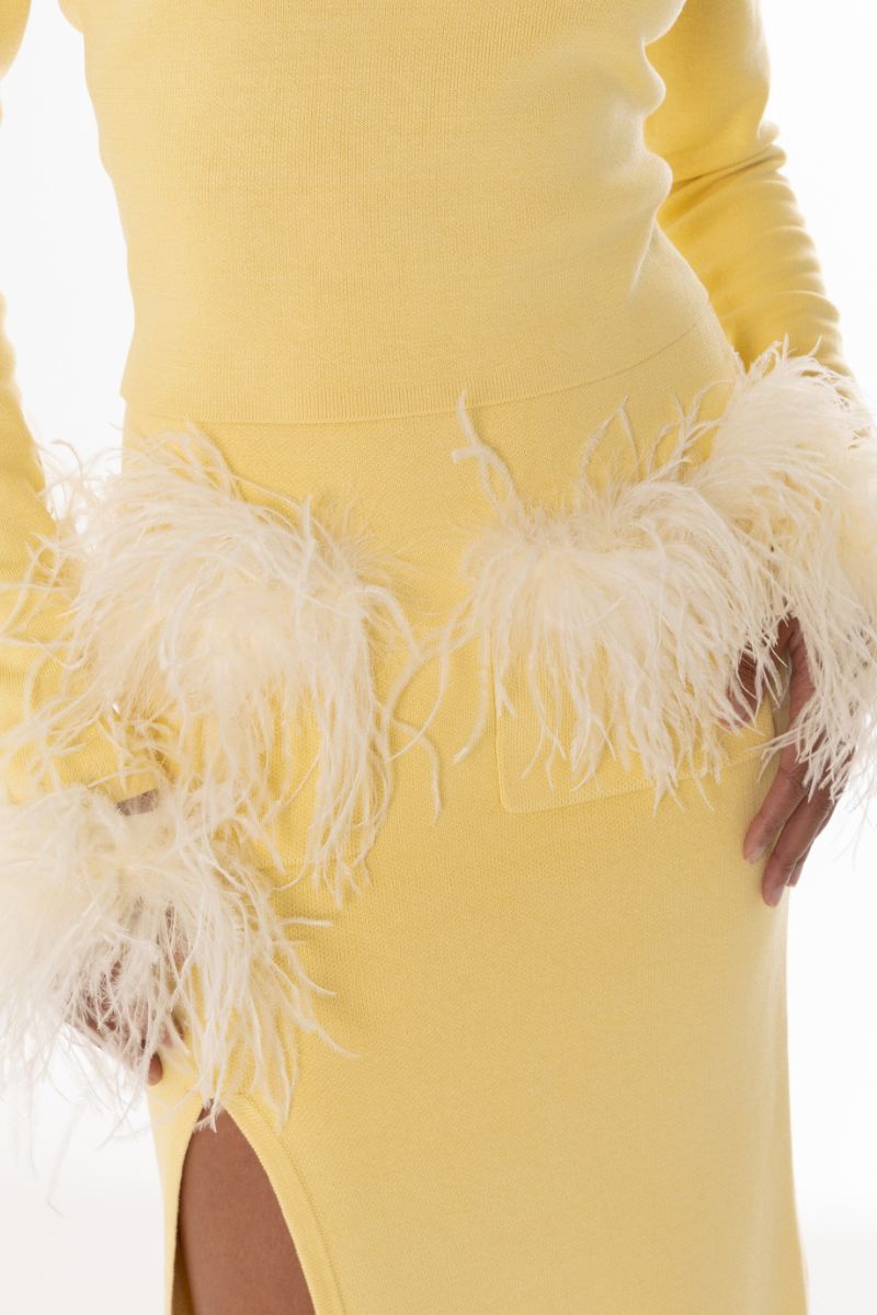 Yellow vanilla knit top by Andreeva with feather cuffs, featuring a cozy knit fabric and stylish detachable feather details.
