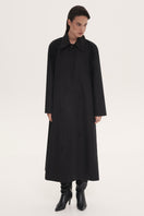 Black trench coat by Delegan, stylish long coat with classic design and button details, ideal for versatile outerwear.
