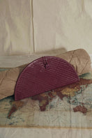 Adriana Castro La Barca leather clutch in burgundy with sleek design and elegant gold clasp.
