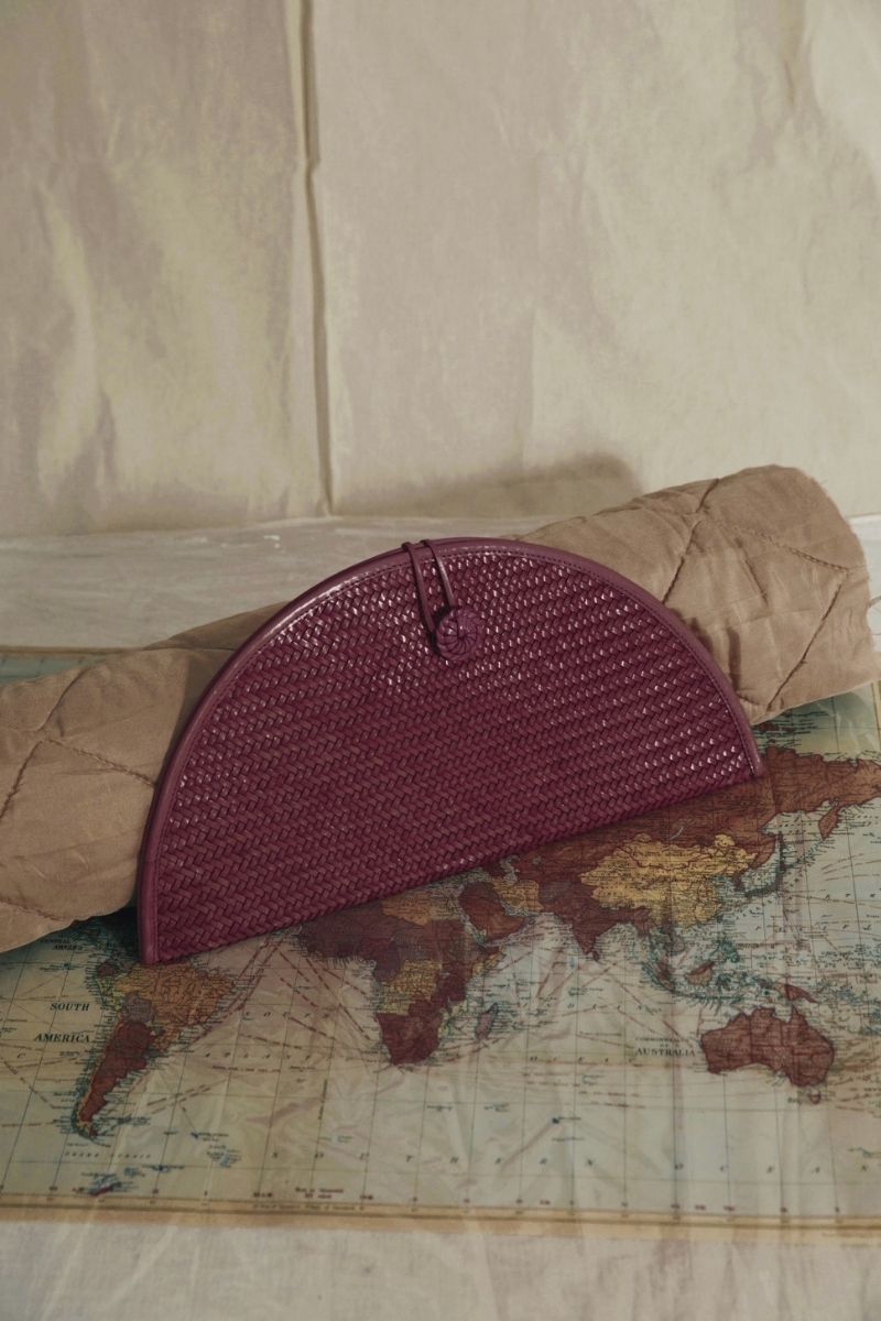 Adriana Castro La Barca leather clutch in burgundy with sleek design and elegant gold clasp.