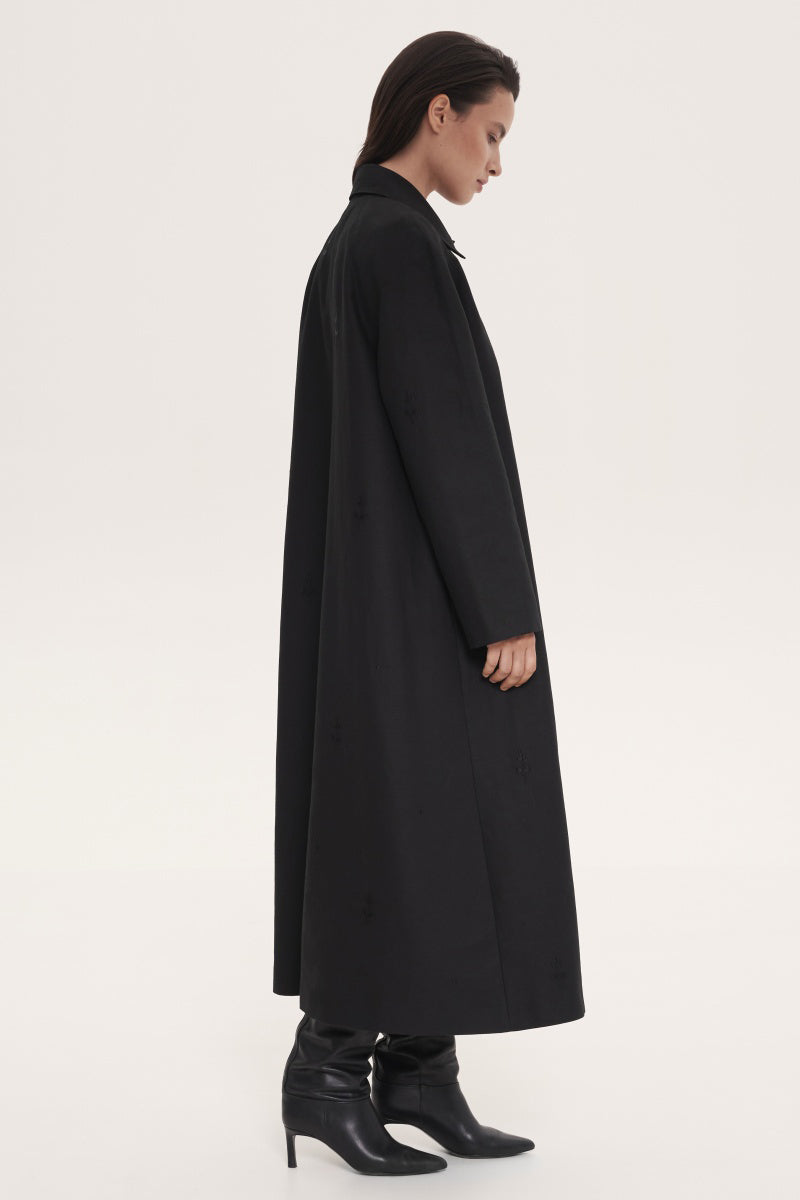 Black trench coat by DELEGAN, showcasing a sleek, stylish coat with a classic design and tailored fit.