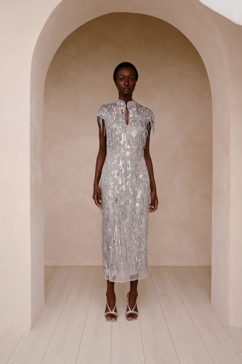 Raishma Amelia gown displayed on a hanger with intricate lace details and elegant flowing fabric.