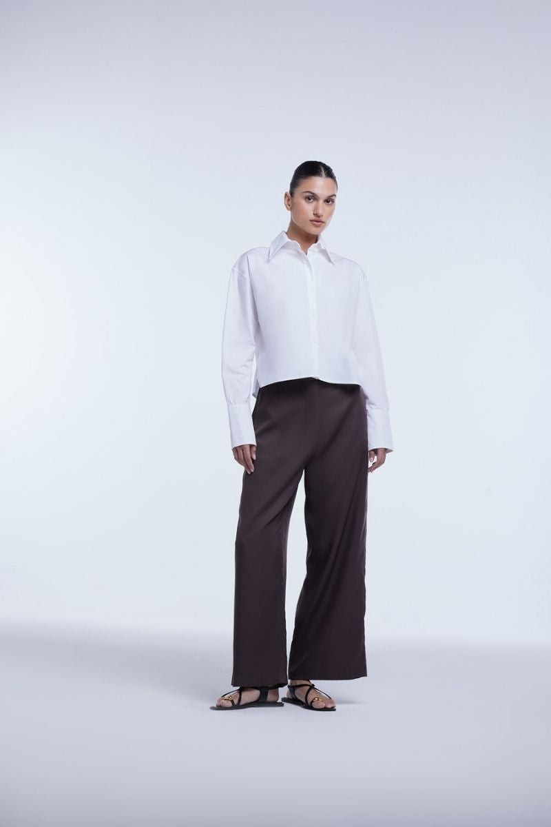 Dāl the Label cropped cotton button-down shirt featuring a relaxed fit, long sleeves, and a classic collar in soft cotton fabric.