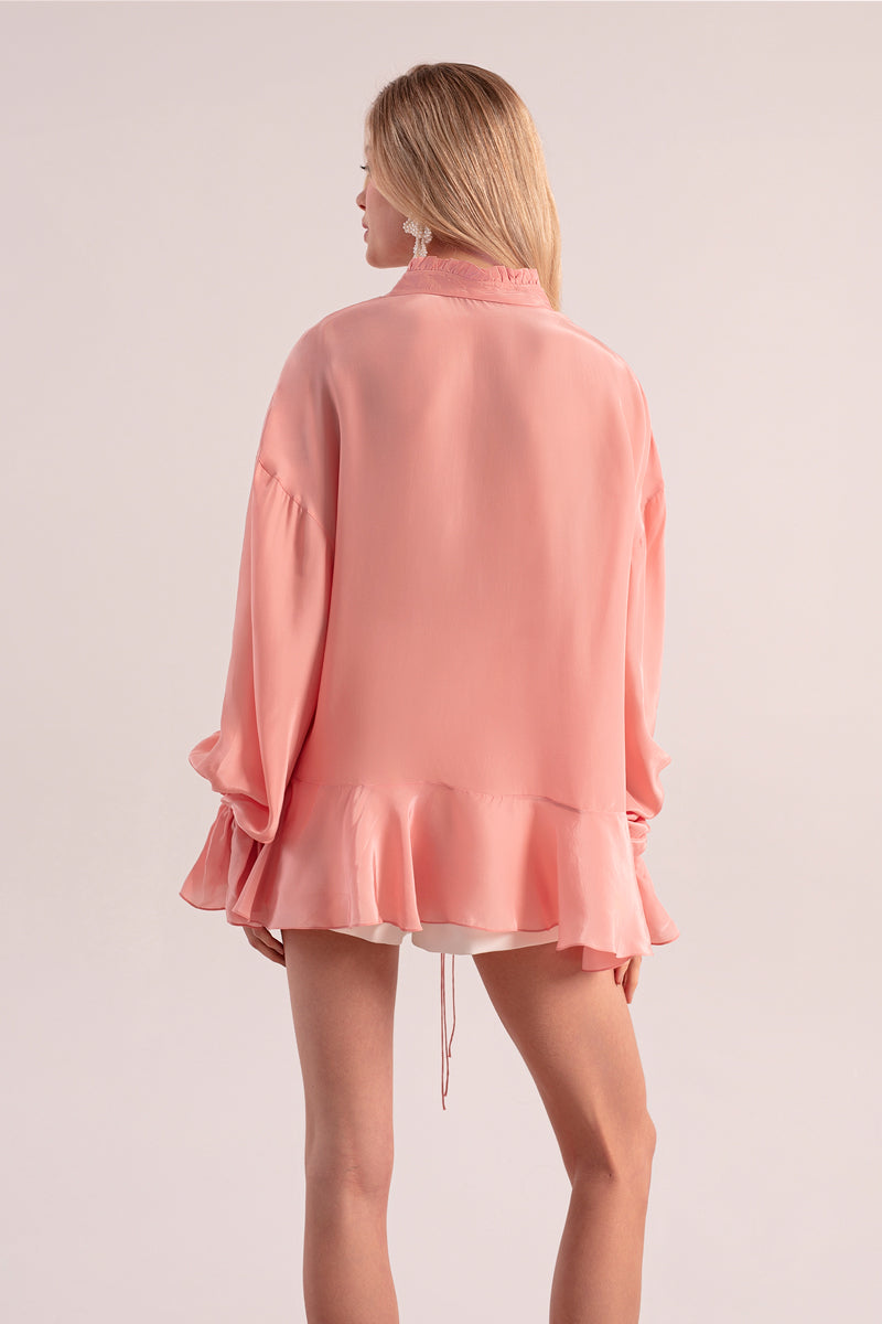 OvertheSea pink splash blouse, a stylish women's top with flowing fabric and vibrant color, displayed on a hanger.