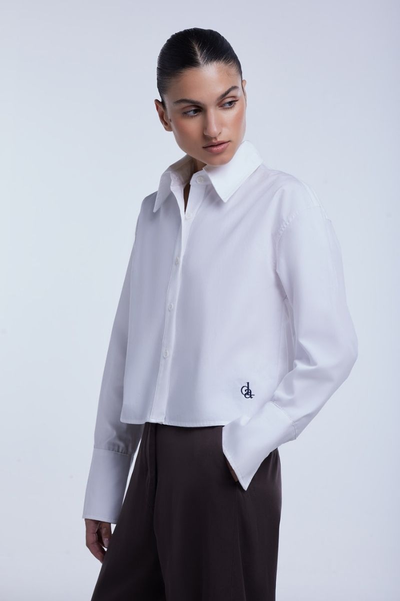 Dāl the Label cropped cotton button-down shirt in a casual style, featuring a classic collar and long sleeves.