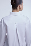 Light blue cropped cotton button-down shirt by Dāl the Label, shown on a hanger with a casual fit and classic collar.