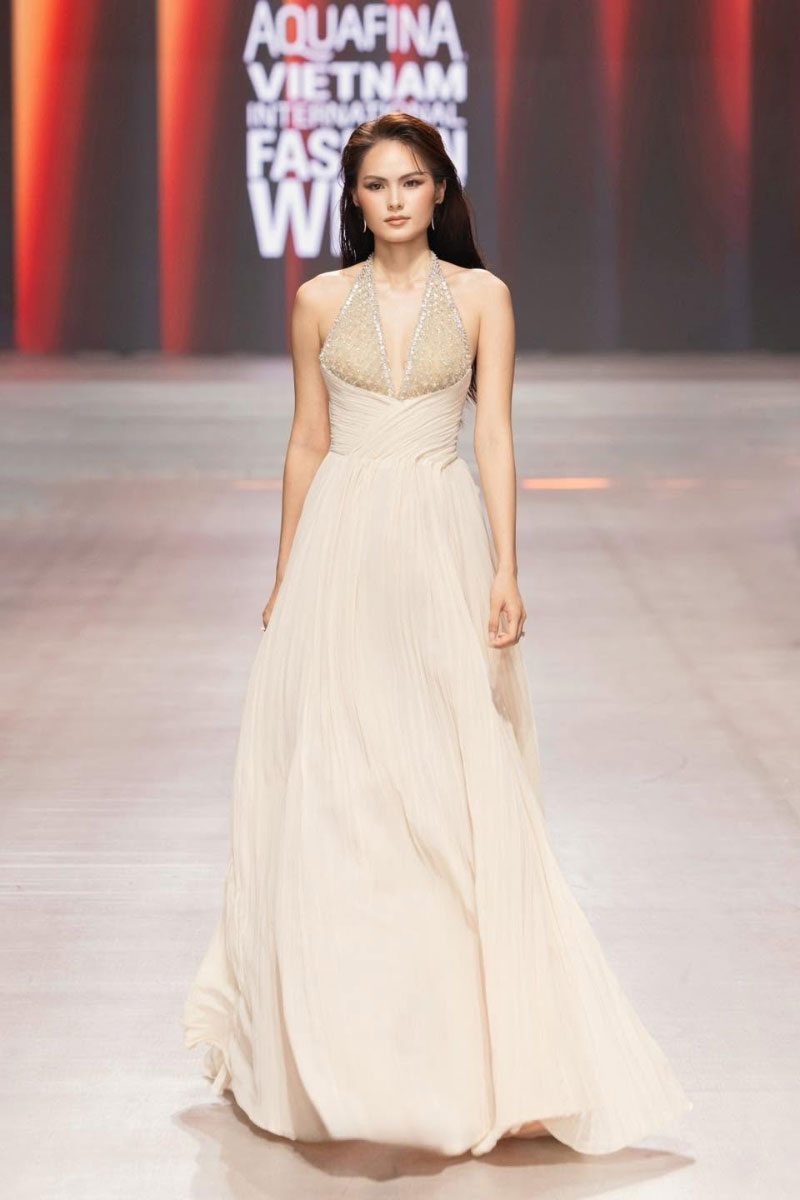 Beige crystal chiffon gown by CEM featuring elegant flowy fabric and intricate crystal embellishments.