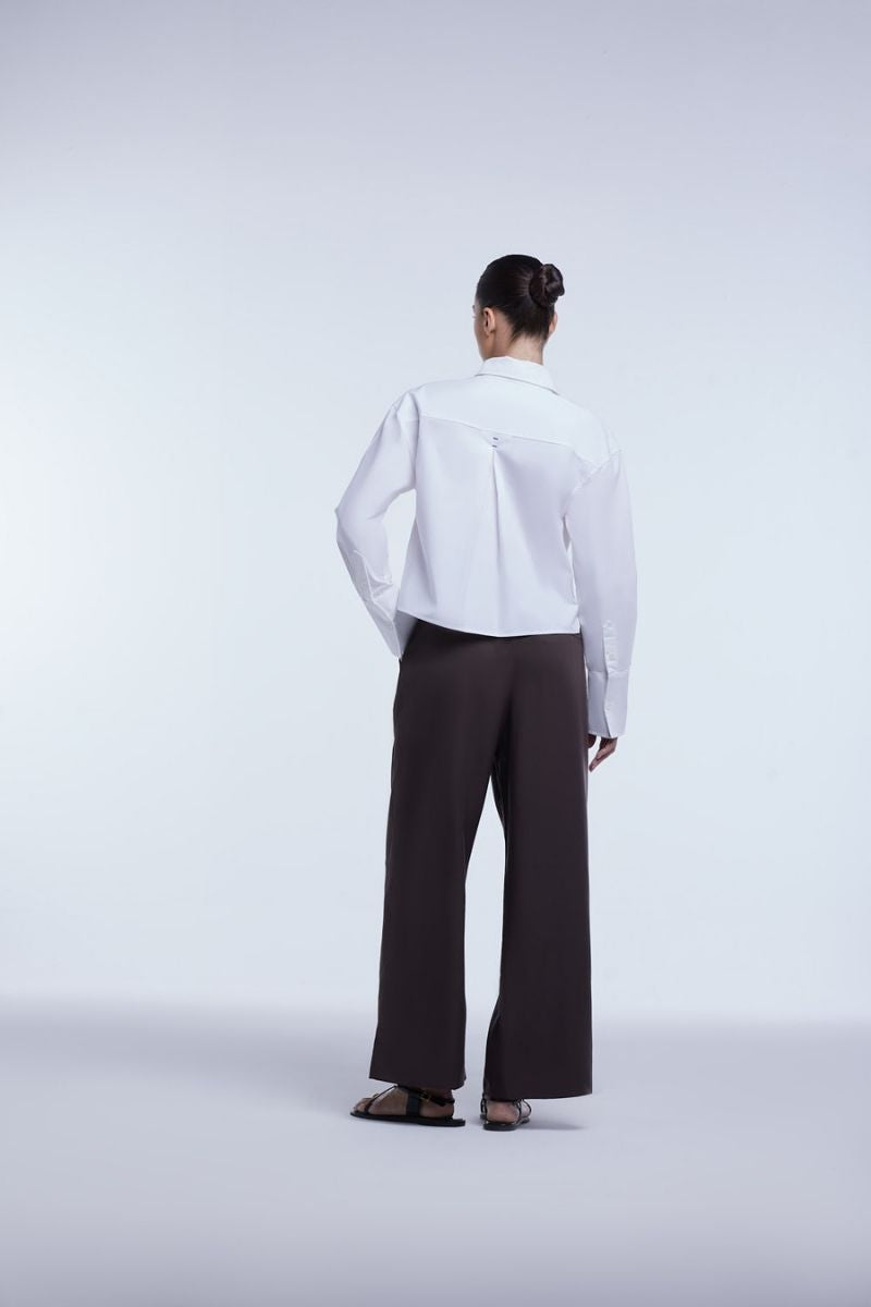 Dāl the Label cropped cotton button-down shirt in light fabric, featuring a classic collar and front button closure.