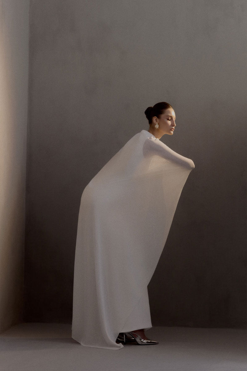 White Plan Chariot Dress gown featuring elegant fabric with intricate details and flowing design for formal occasions.