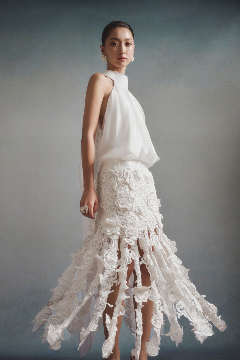 White Plan Flora halter midi dress hanging on a wooden hanger, showcasing floral pattern and elegant halter neckline.