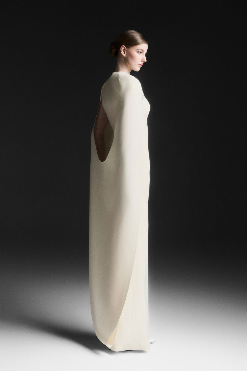 Maison Des Copains NYXELLE cape sleeve floor-length gown in vanilla cream, featuring elegant flowing fabric and sophisticated style.