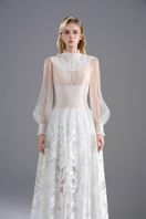 White lace high-neck maxi dress by ROSEE DE MATIN, featuring intricate lace details and a flowing silhouette.