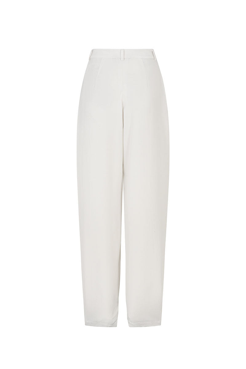 White tapered leg trousers by Valenciani, showing a close-up of the stylish, fitted design and smooth fabric.