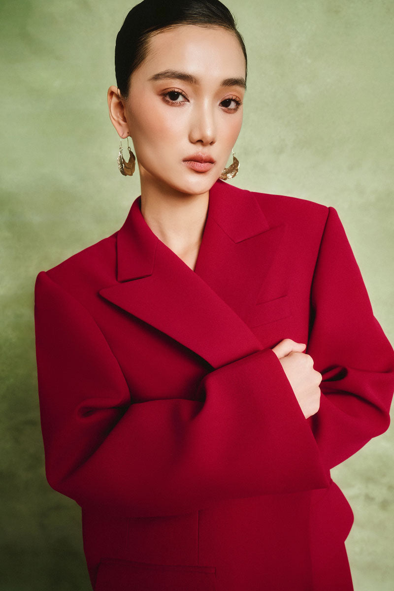 White Plan Scarlet tailored coat displayed on a hanger, showcasing its sleek design and structured fit in a neutral setting.