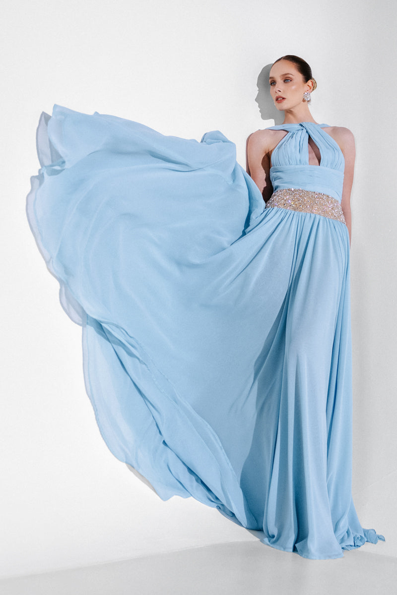 Elegant blue embellished chiffon gown by Monika Dimova showcased with intricate beadwork and flowing fabric.