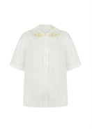Elegant milk silk shirt with ornament details by DELEGAN, showcasing a stylish and comfortable design.