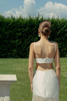 Ivory fringe maxi skirt by Monika Dimova displayed on a mannequin, featuring flowing fabric and layered fringe details.