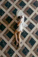 White embellished cape mini dress by Monika Dimova, featuring intricate detailing and stylish design for elegant occasions.