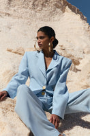 Blue IKINITA THE SUN jacket hanging on a hanger, showcasing a stylish lightweight jacket for casual wear.