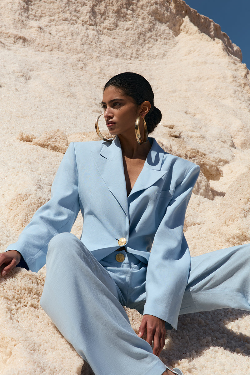 Blue IKINITA THE SUN jacket hanging on a hanger, showcasing a stylish lightweight jacket for casual wear.