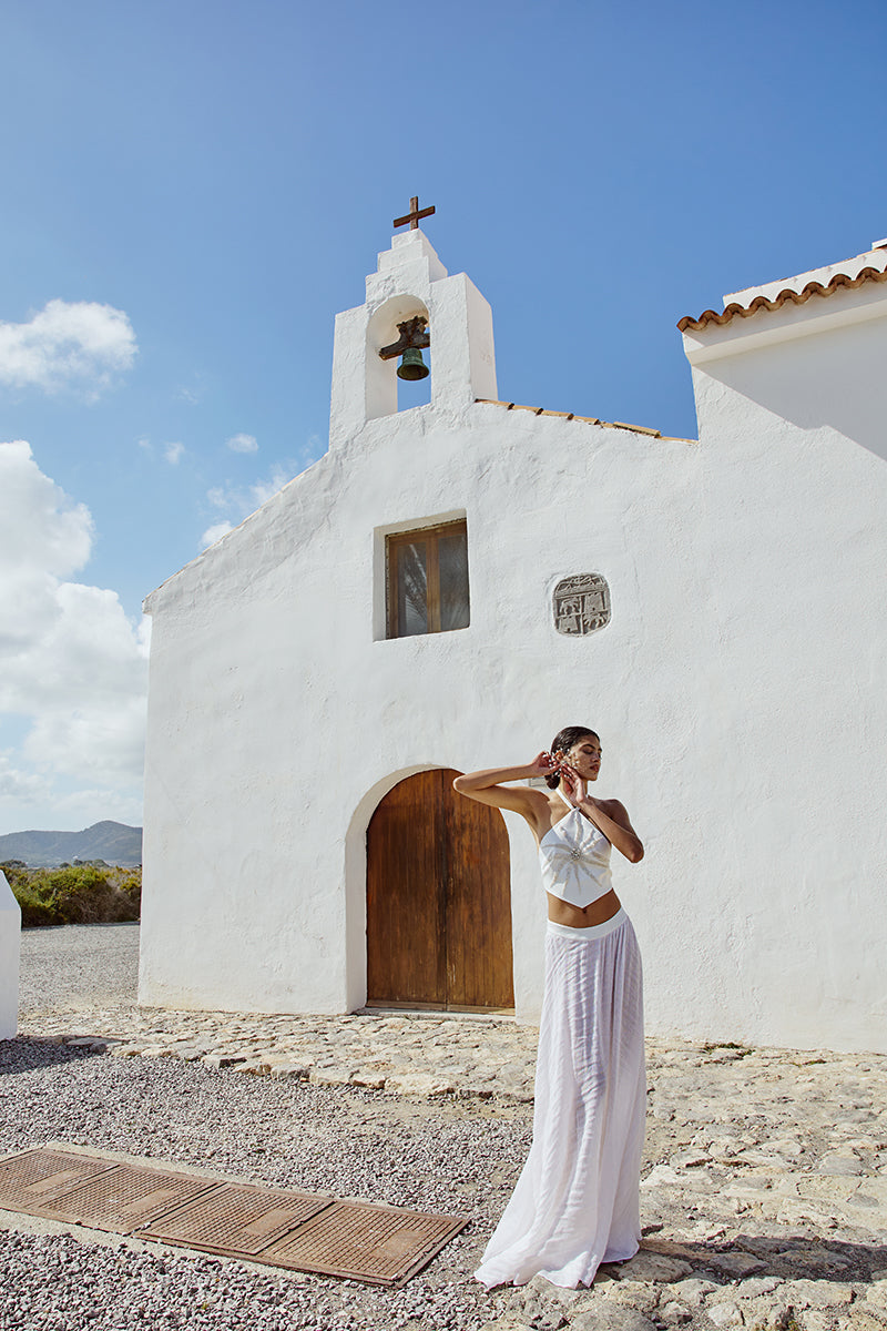 White IKINITA The Innocent Top, a stylish women's blouse with a relaxed fit and minimalist design, shown on a model.