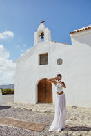 White IKINITA maxi skirt called THE INNOCENT SKIRT, flowing fabric with a relaxed fit, displayed on a model against a neutral background.