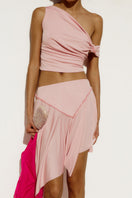 Baby pink IKINITA The Fool mini skirt displayed on a mannequin, showcasing its stylish design and fit.