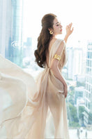 Elegant nude silk evening gown by Do Long, flowing fabric with a fitted bodice and floor-length design.