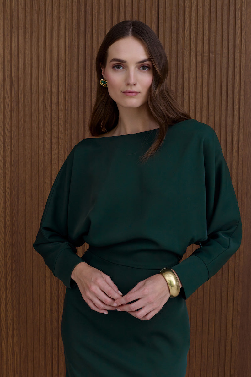 Undress Agalia deep green off-the-shoulder midi dress displayed on a hanger with flowing fabric and elegant design.