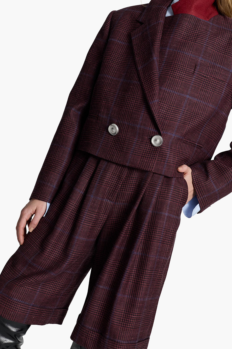 Acaria Studio burgundy shorts with blue check pattern, casual fit, and fabric texture visible on the front.