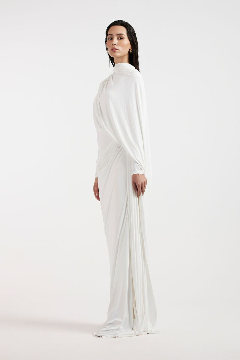 Deme By Gabriella Nadia white draped gown with elegant flowing fabric and sophisticated silhouette on a model.