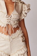 Beige handmade lace detailed ruffled linen jacket by HALEIA, featuring intricate lace accents and ruffled design for stylish tops.