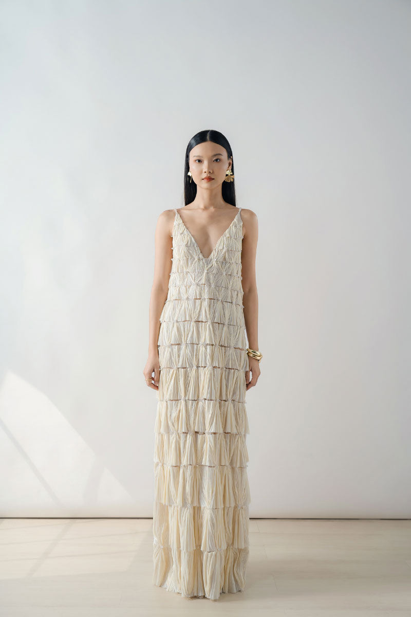Beige deep V-neck tiered pleated maxi dress by DOC BAN, featuring flowing fabric and layered design for elegant style.