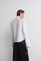 White historical shirt by Acaria Studio featuring vintage-inspired design and tailored fit, displayed on a mannequin.