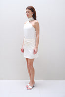 Cream AMIRA mini skirt by Aidan & Ice, featuring a fitted waist and stylish short length, displayed on a model.
