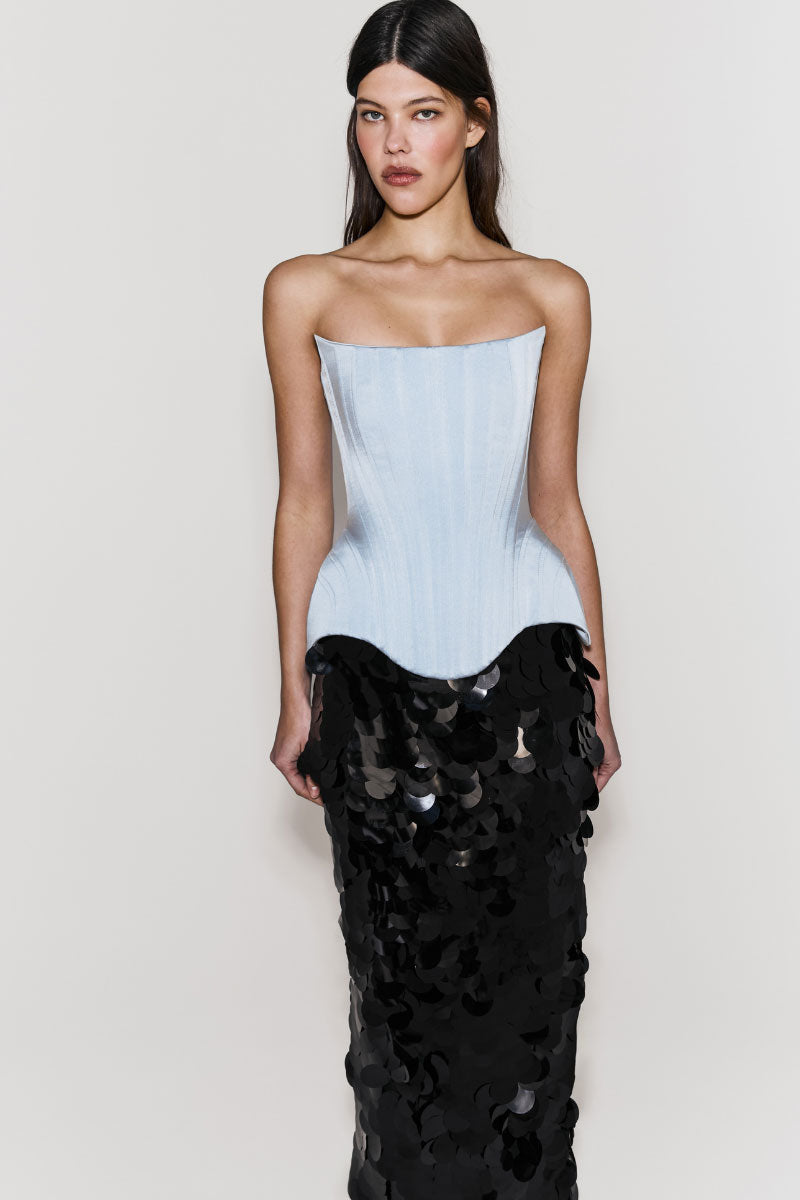 Light-blue Irma corset top by Balykina, featuring structured design and smooth fabric, displayed on a hanger.