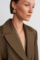 Acaria Studio Earth Blazer in Hazelnut Brown, tailored blazer with lapels and front pockets, displayed on a hanger.