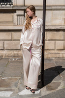 Soft blush pink silk pajamas set by Not Just Pajama featuring long sleeves and relaxed fit for comfortable loungewear.