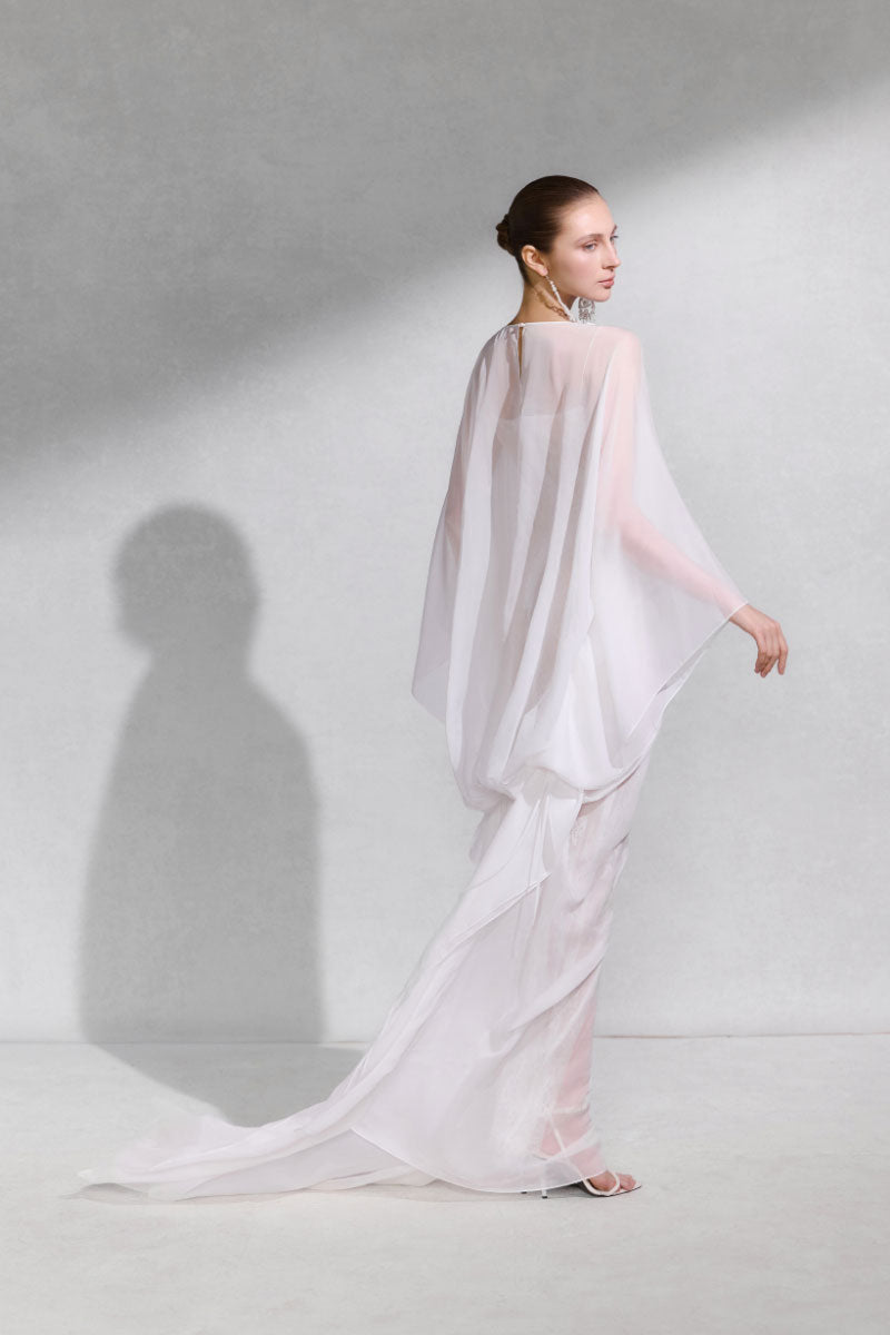 Arti Apparel GENUS maxi dress featuring a flowing fabric and elegant design, displayed on a hanger against a neutral background.