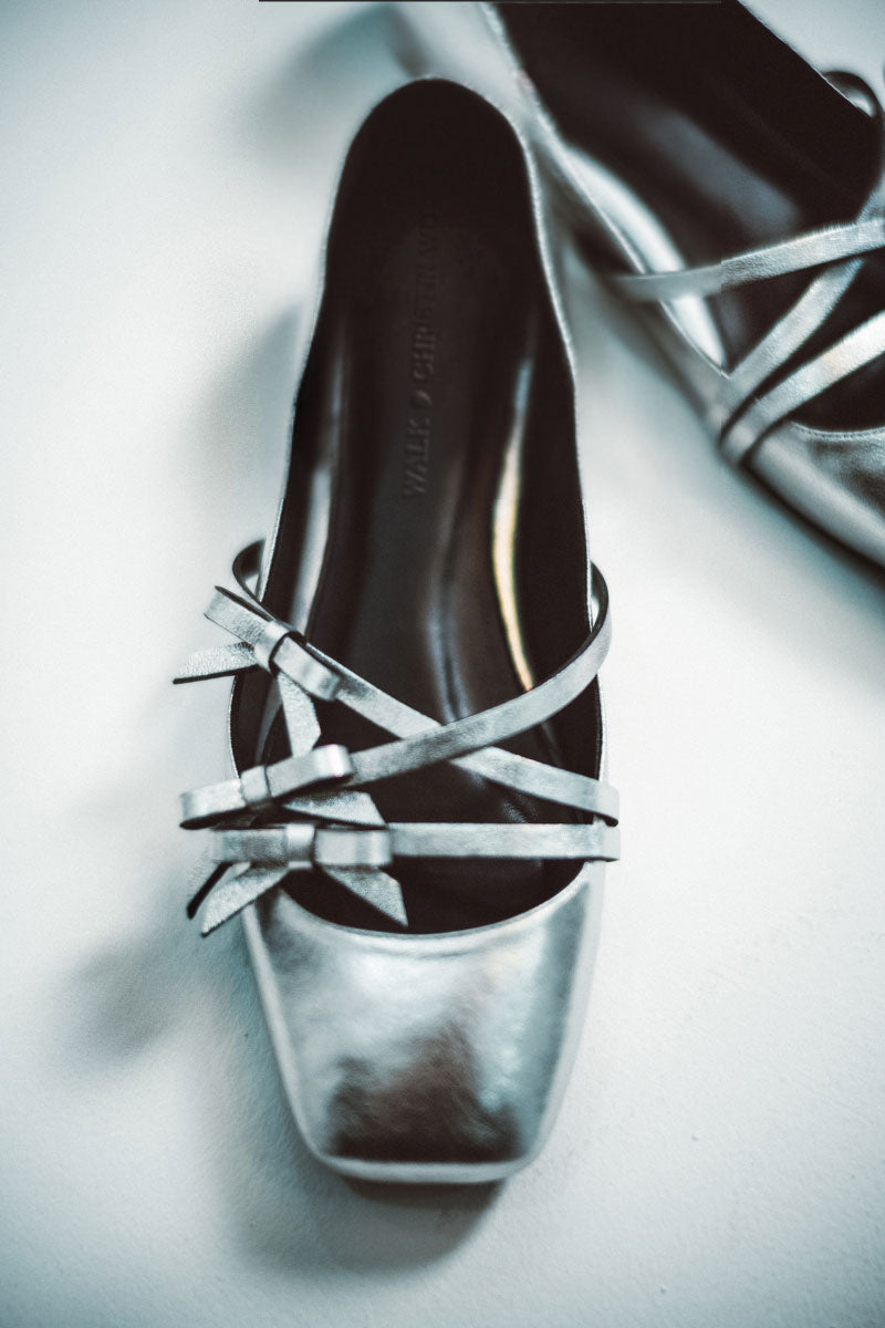 Christin Wu Annaya silver flats featuring sleek design and pointed toes, perfect for stylish casual or formal wear.