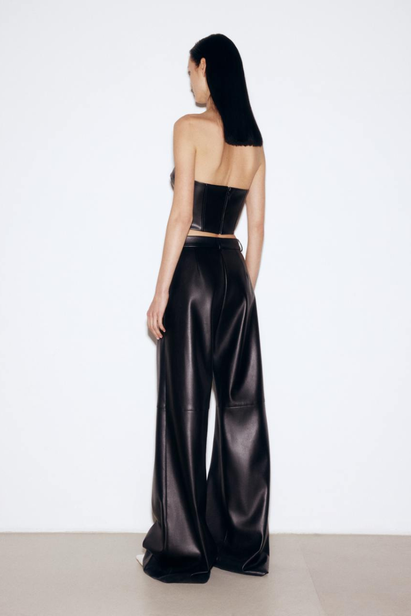 Black faux leather mini corset top by ELENAREVA featuring a fitted design with structured bust and adjustable straps.