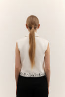 DELEGAN vest with decorative ornament, stylish sleeveless top featuring intricate embellishments and detailed fabric design.