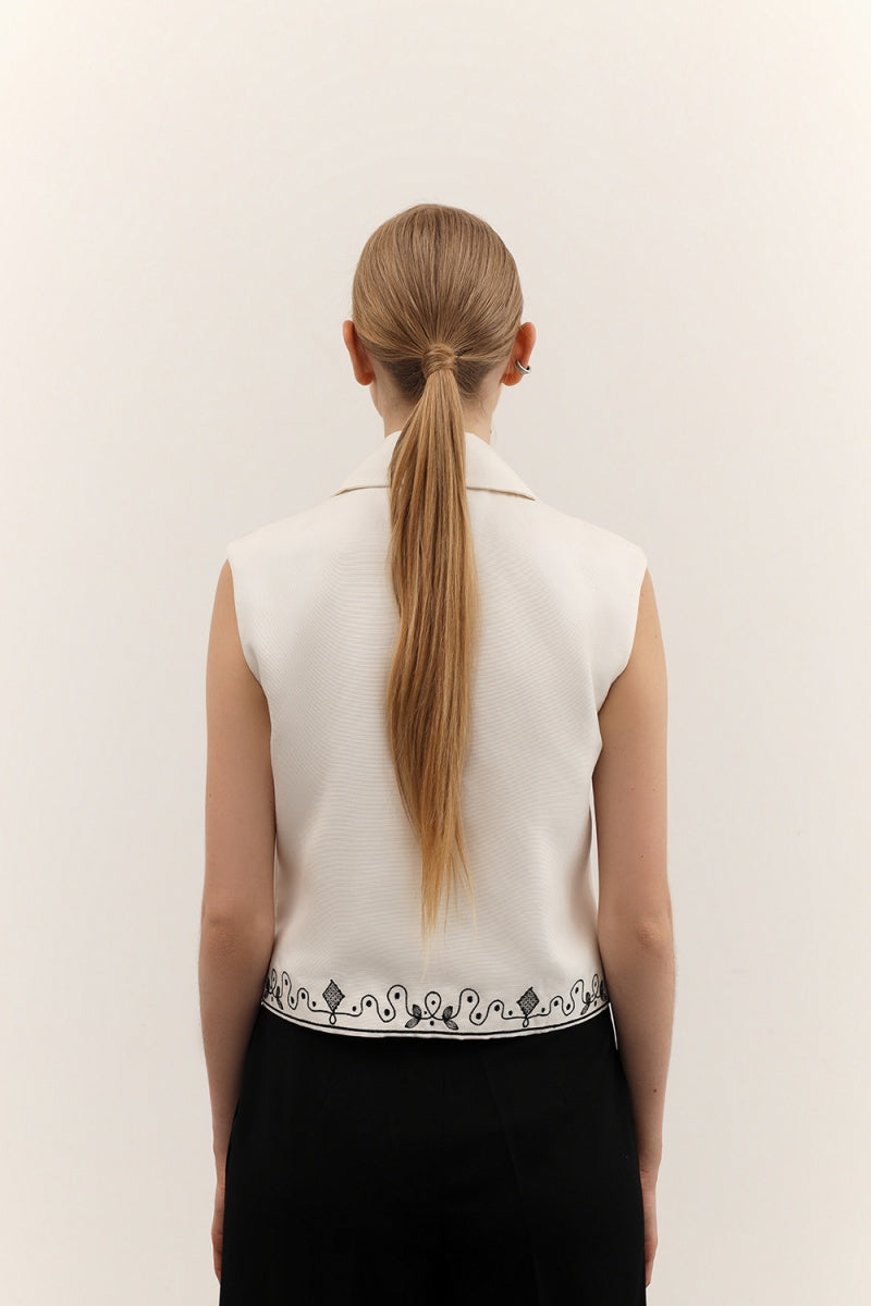 DELEGAN vest with decorative ornament, stylish sleeveless top featuring intricate embellishments and detailed fabric design.