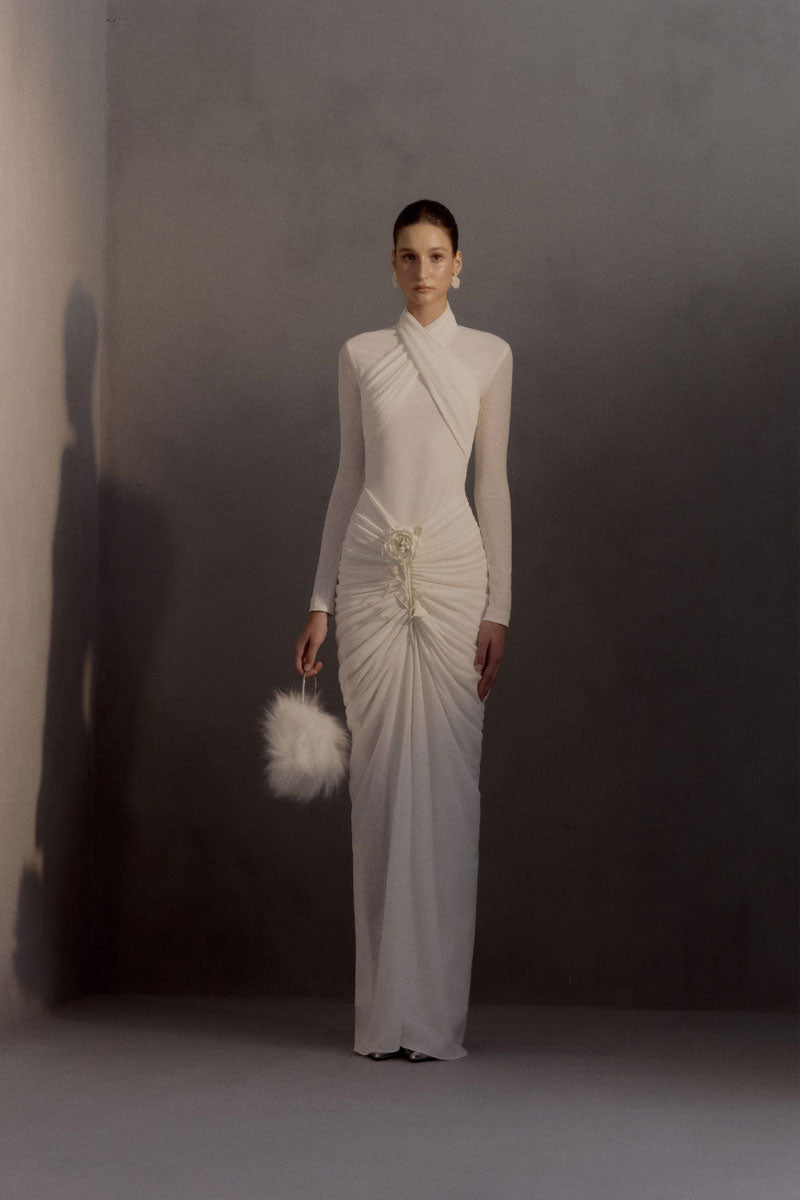Elegant White Plan Armetis gown displayed on a hanger, showcasing its flowing fabric and sophisticated design.