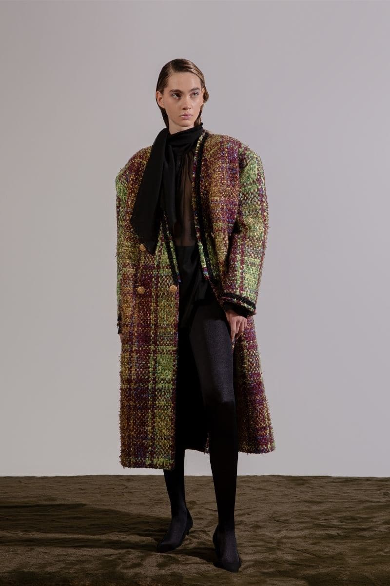 Lalo oversized brown tweed coat hanging on a wooden hanger, showcasing its textured fabric and relaxed fit style.