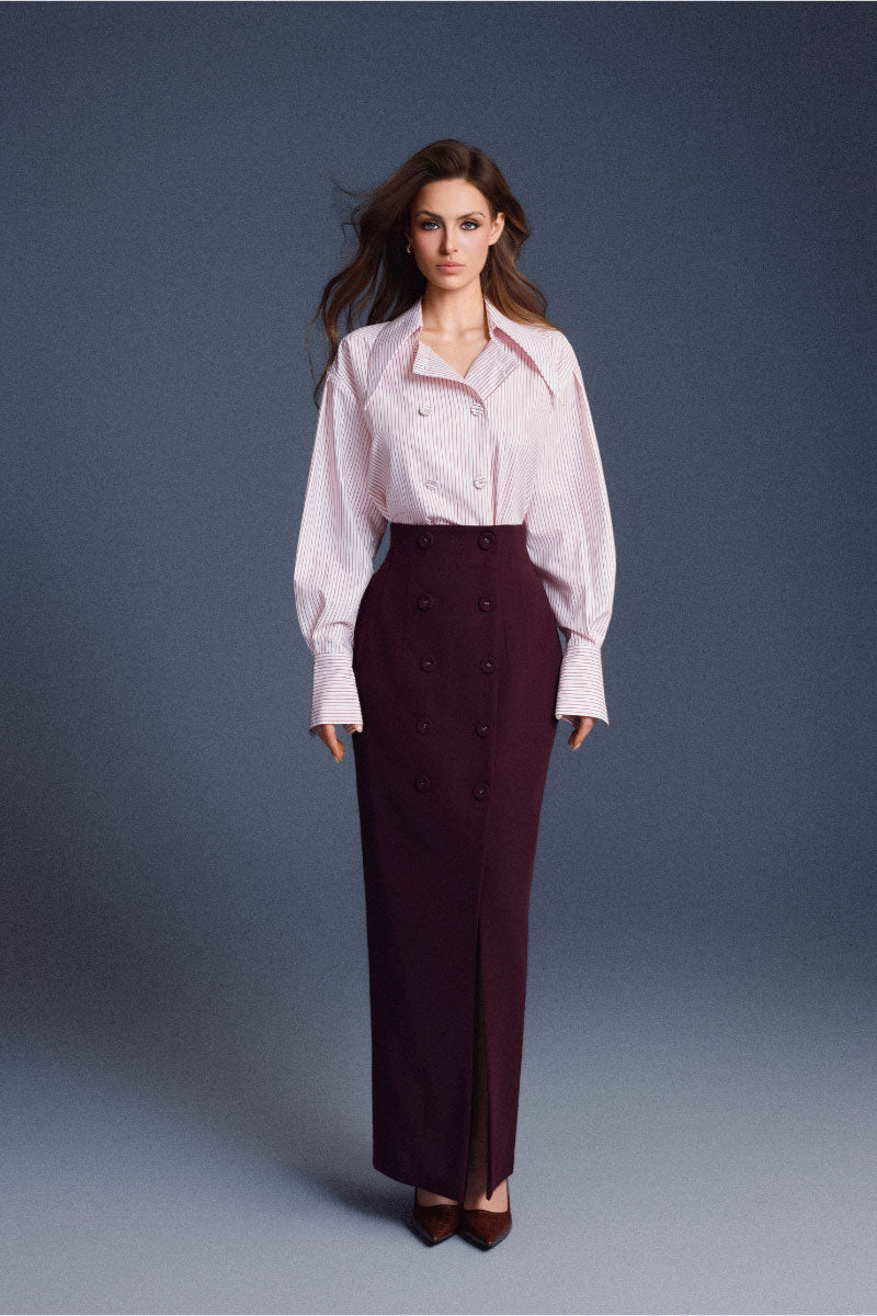 Keira Tong buttons sculpted maxi skirt with a fitted waist and flowing silhouette, shown in a neutral fabric.