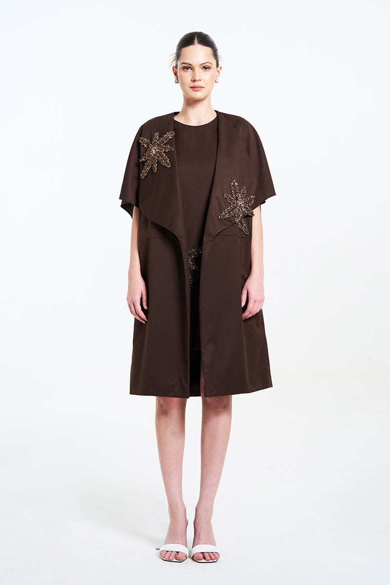Aidan & Ice NAIRA outer coat in brown, stylish long coat with a tailored fit, displayed on a hanger.