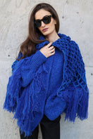 Blikvanger fringed poncho-style cardigan with loose fit and textured fabric, featuring fringe details along the hem and open front.