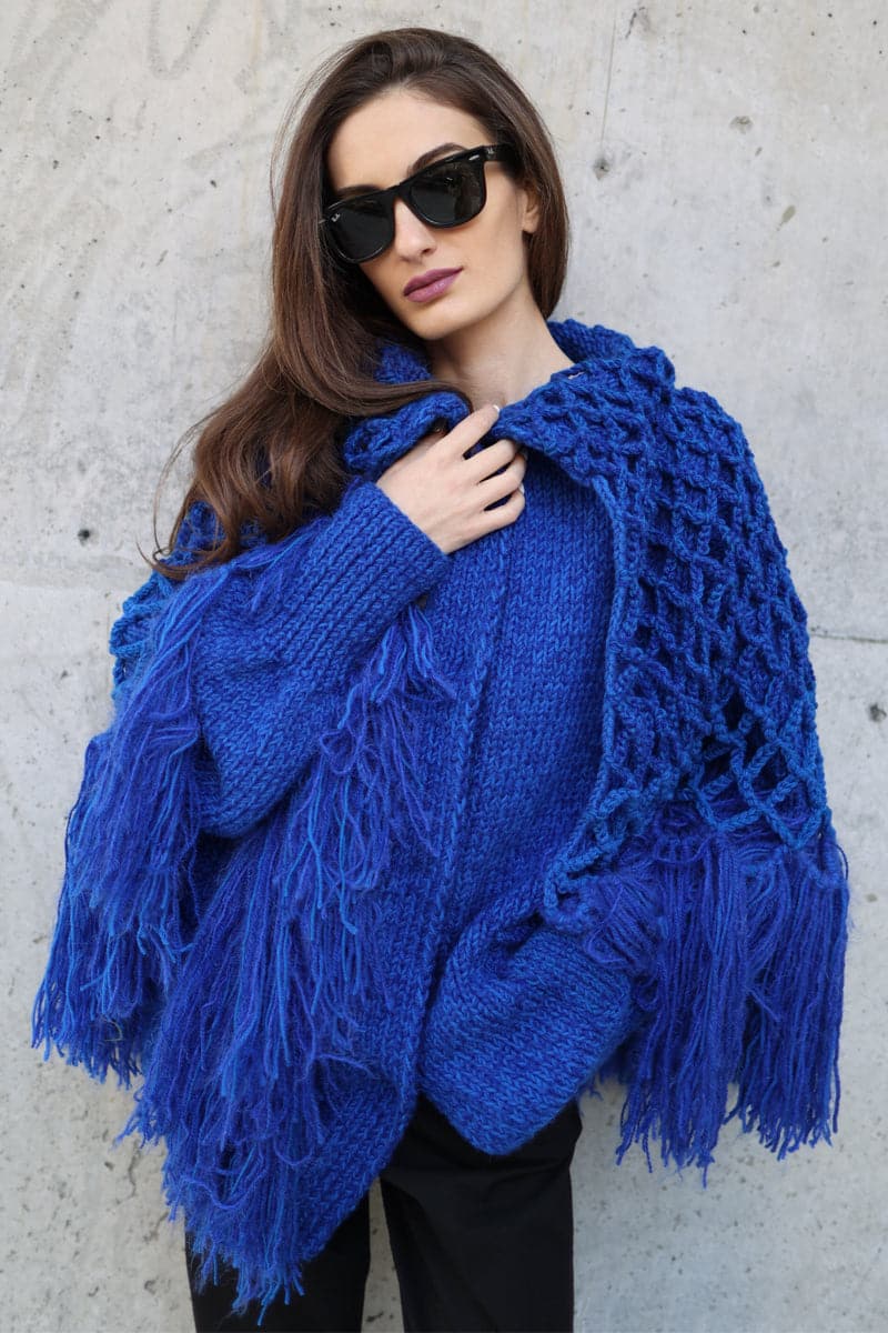 Blikvanger fringed poncho-style cardigan with loose fit and textured fabric, featuring fringe details along the hem and open front.